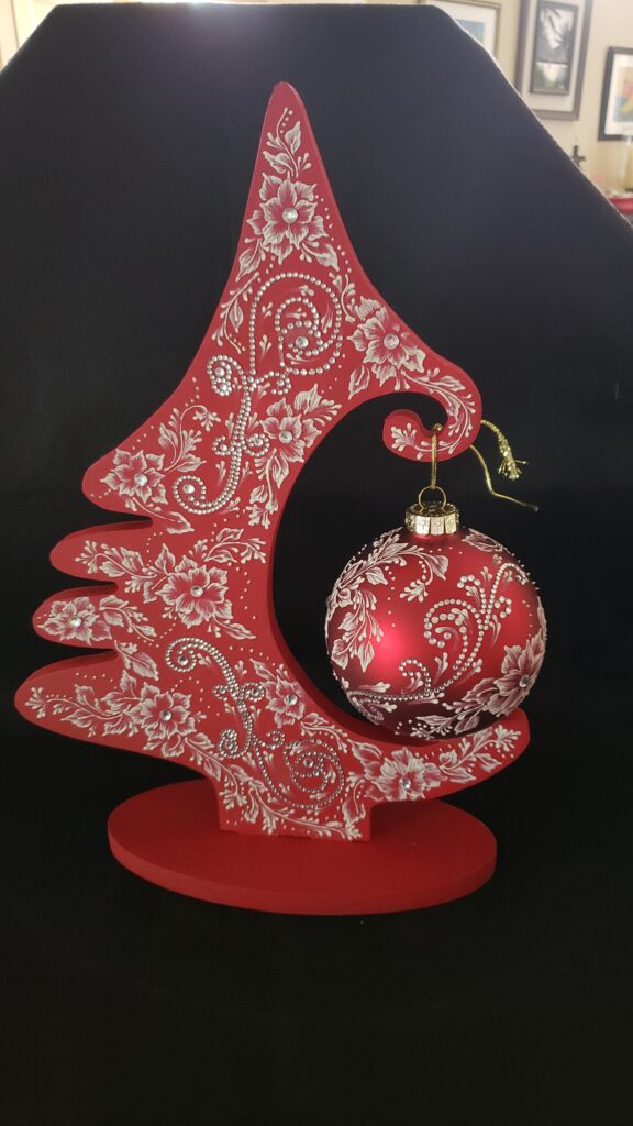 a hand painted red and white christmas ornament by Gerri Zoppa